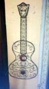 A wrought iron wall hanging of a guitar