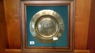 A framed brass plate