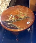 A circular table decorated with an oriental scene
