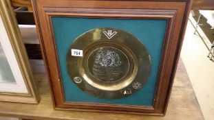 A framed brass plaque