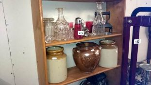 A mixed lot of glass, stoneware jars etc, 2 shelves