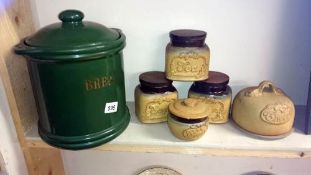 A bread crock and storage jars