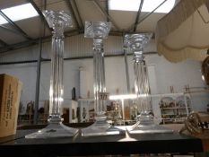 A set of 3 graduated glass candlesticks