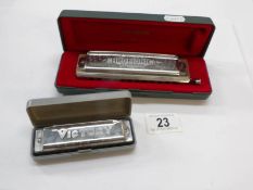 A cased Hohner super Chronomica and a Victory Harmonica