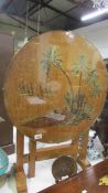 An occasional table with oriental scene protected by a glass top