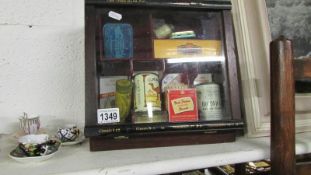 A small shop display cabinet with tins