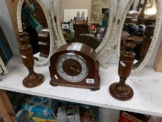 An oak mantel clock and a pair of oak candlesticks