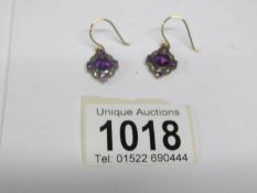 A pair of amethyst and diamond earrings