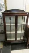 An Edwardian mahogany display cabinet on ball and claw feet