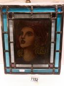A leaded and stained glass panel with female portrait