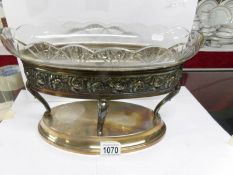 A large oval glass bowl on a plated stand