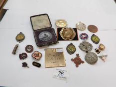 A mixed lot of enamel and military badges and tokens