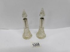 A pair of cut glass perfume bottles with silver collars