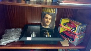 A collection of model cars including Formula 1 and a Nigel Mansell autobiography