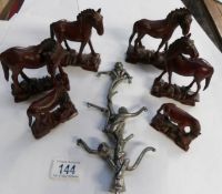 6 carved wood horses and a metal monkeys up a tree figure