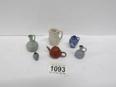 A miniature terracotta teapot and quantity of miniature jugs