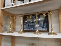 A pair of brass candelabra and a pair of matching candlesticks