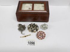 A musical jewellery box containing 1960/70's brooches