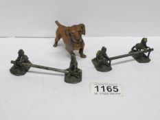 A cold painted spelter dog and a pair of knife rests depicting horses jumping a fence,
