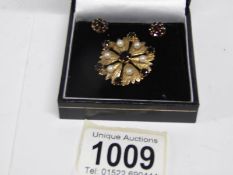 A 9ct gold garnet and seed pearl brooch and a pair of earrings