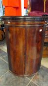 A Victorian mahogany barrel front corner cupboard