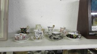 8 various miniature tea cups and saucers together with a miniature Toby jug