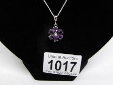 An amethyst floral pendant with diamond centre