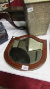 An early 20th century mahogany framed shield shaped bevel edged mirror