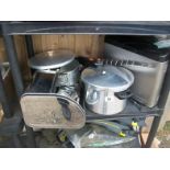 A shelf of stainless steel kitchen ware