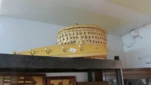 A pine and brass hook rack and a sewing basket