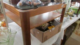 A glass topped teak coffee table