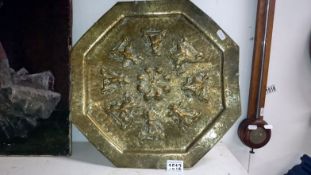 An Indian brass engraved and embossed octagnal wall plaque