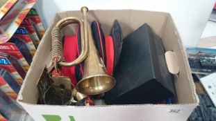 A box of military items inc. bugle, hats etc.