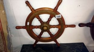 A brass bound light mahogany ships wheel marked V.M.