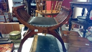 A mahogany piano stool with leather seat