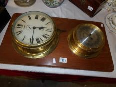 A brass ship's clock and a brass ship's barometer on wooden back board