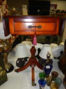 A dark wood stained side table with drop leaves and draw