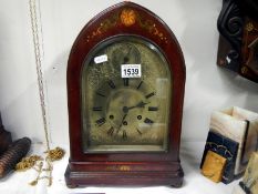 A dark stained with painted decoration bracket clock with silvered face and Westminster chime