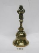 A 19th century Oriental brass bell surmounted two faced Diety figure,