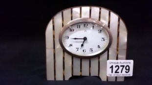 A mother of pearl mantel clock with oval silver rim