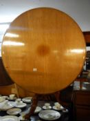 A Victorian round tip up dining table on tripod base