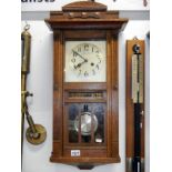 An art deco oak wall clock with day and date reel