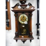 A wall clock with pendulum and key