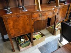 An Edwardian inlaid mahogany sideboard with serpentine front and sliding tamba doors