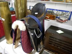 A horse saddle with stirrups and other accessories on stand