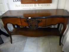 A serpentine dark stained sideboard with 1 draw and under shelf