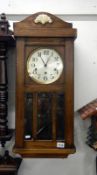 A 1930's oak wall clock with bevelled glass panels
