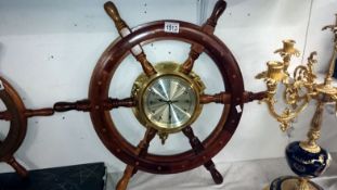 A brass ships clock mounted inside a ships wheel