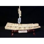 A carved ivory Chinese junk on stand