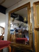 A large gilt framed bevel edged mirror